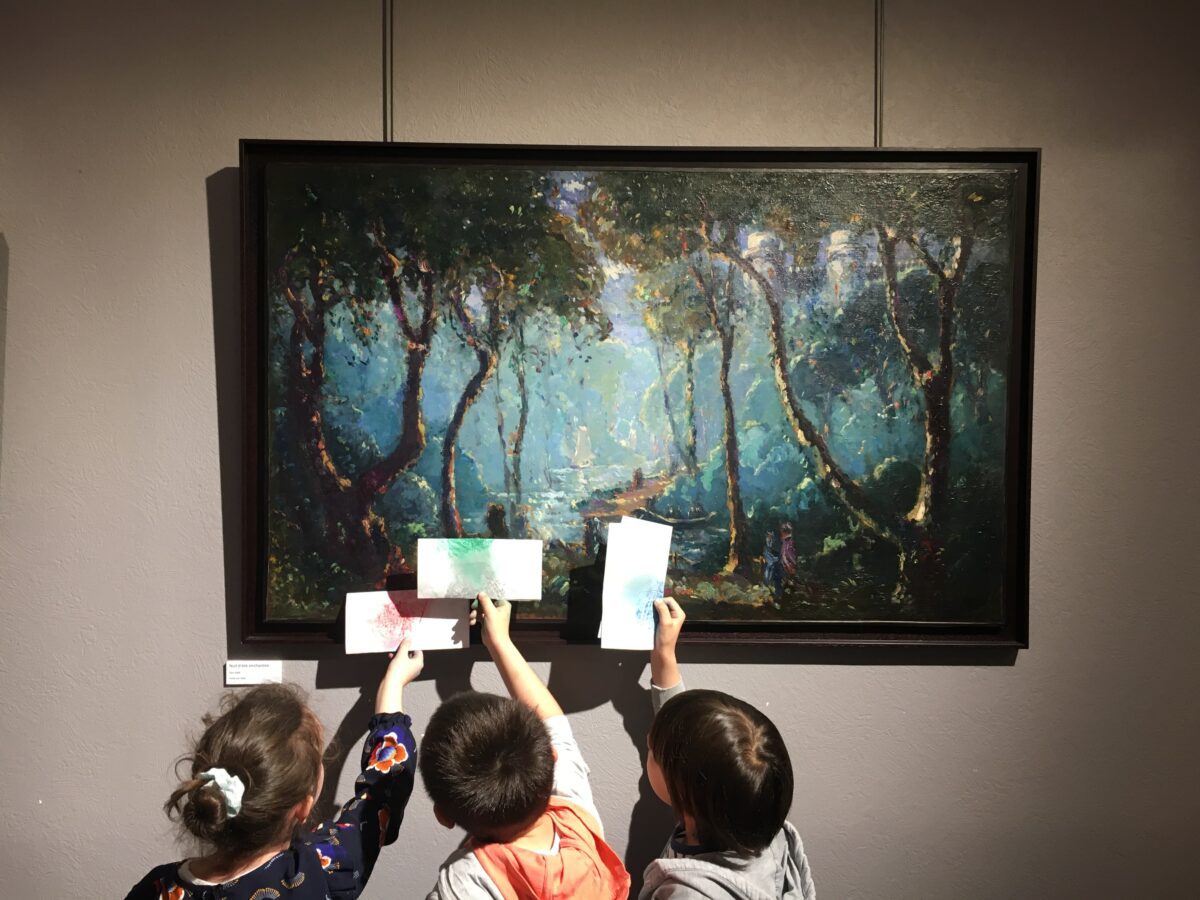 Des enfants regardant un tableau d'Emmanuel de la Villéon